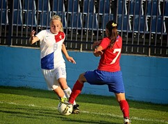 Zwei Fußballerinnen am Spielfeld vor leeren Zuschauerrängen