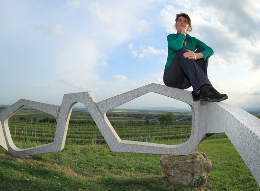 Geschäftsführerin der Leader-Region Kamptal auf einer Skulptur, einer sehr...
