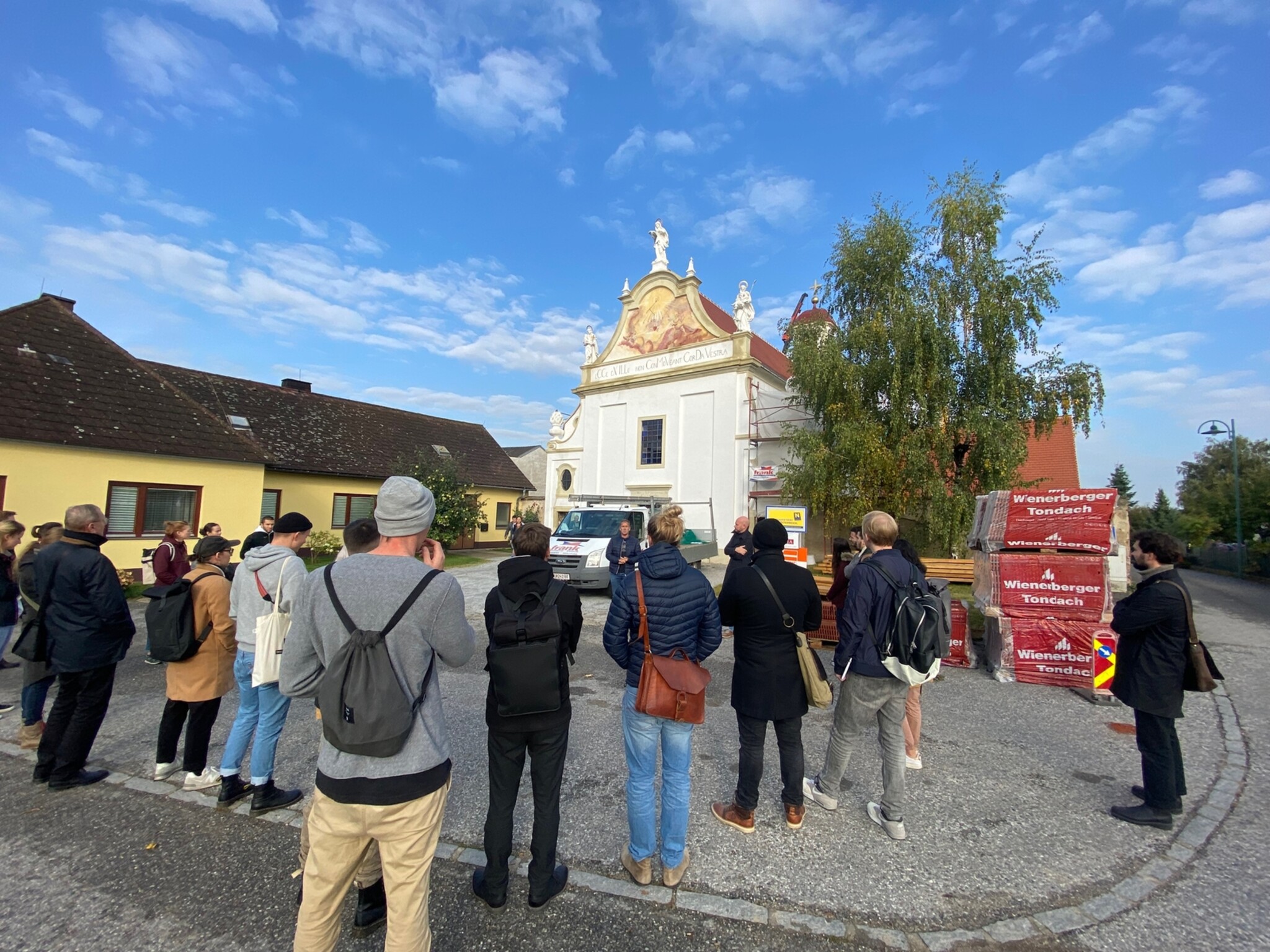 Rückenansicht einiger Studierender der TU Wien, im Hintergrund Grupftkapelle Röhrenbach