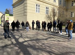 Mehrere Personen im Halbkreis stehend vor dem ehemaligen Gefängnis in Kichberg...