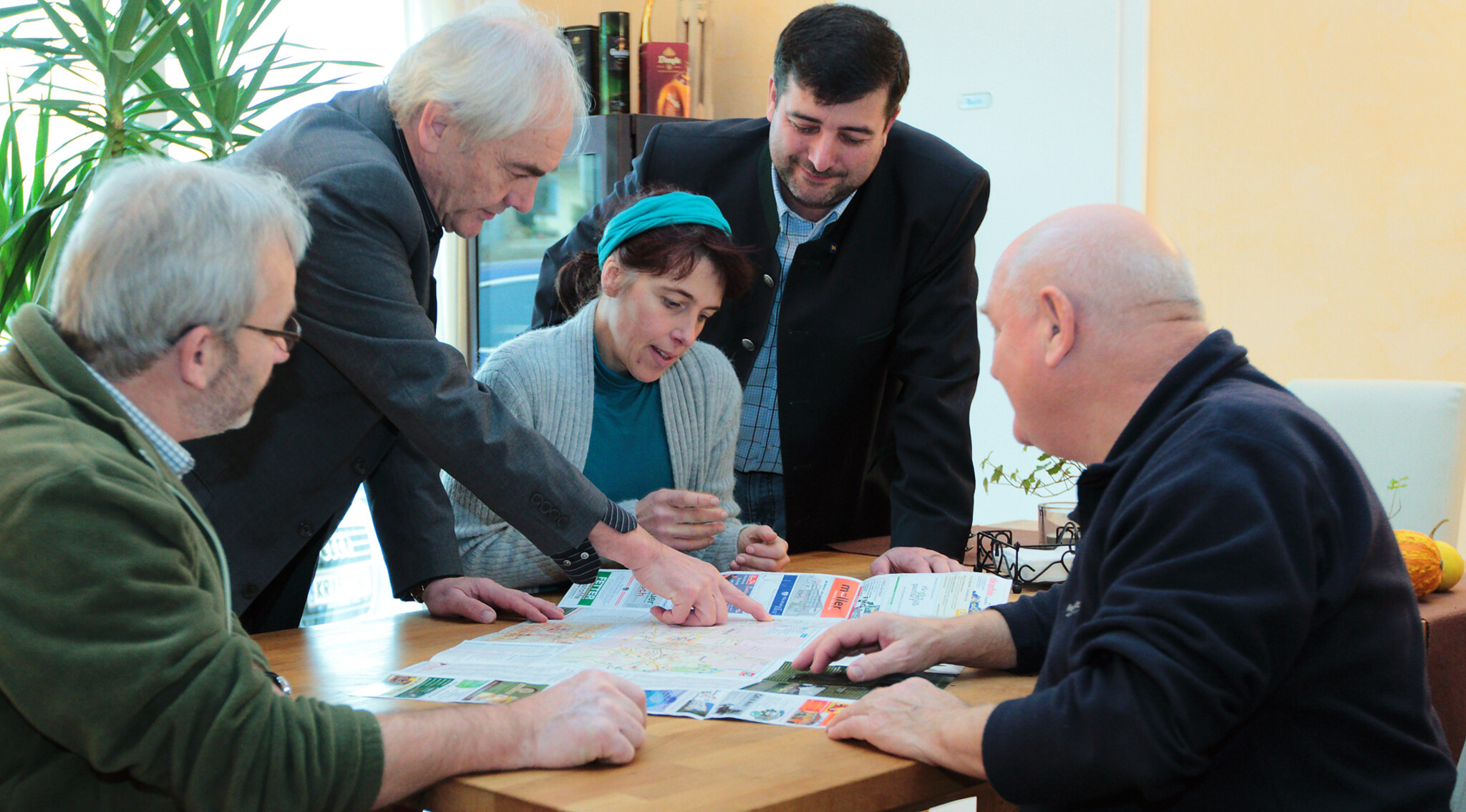 Fünf Personen der Leader-Region Kamptal an einem Tisch sitzend und über Landkarte gebeugt