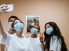Vier Personen mit Mundschutz machen ein Selfie vor Monalisaportrait