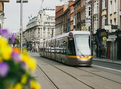 Fahrende Straßenbahn vor Häuserfront