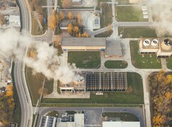 Areal mit Industriegebäude und rauchendem Schlot