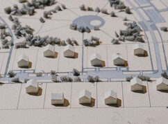 mehrere Häusermodelle auf einem Plan - eine Siedlung simulierend